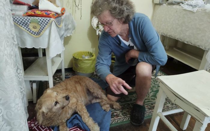 Dona Vildi com o cão Netinho. Ela benze, também, os animais