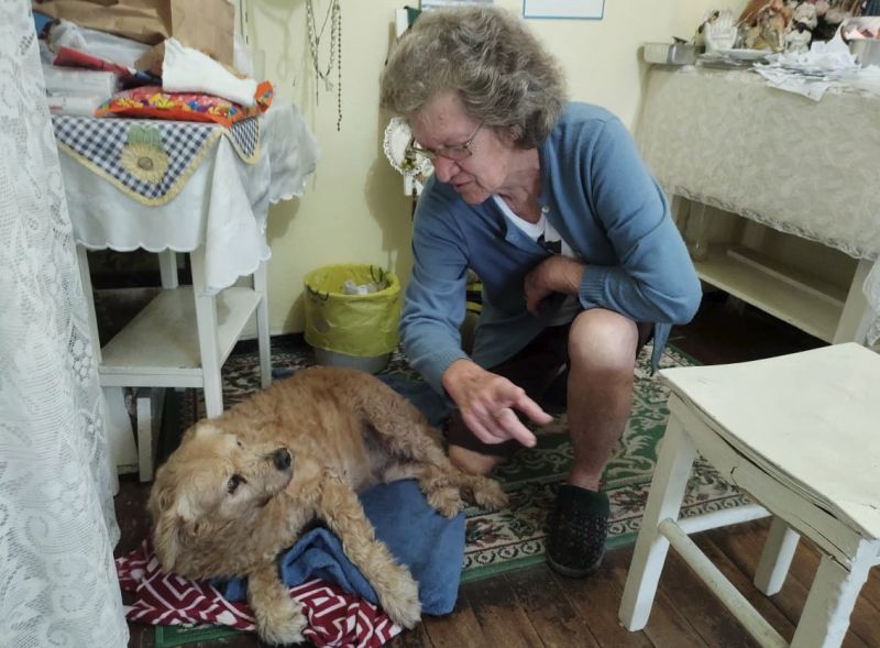 Dona Vildi com o cão Netinho. Ela benze, também, os animais