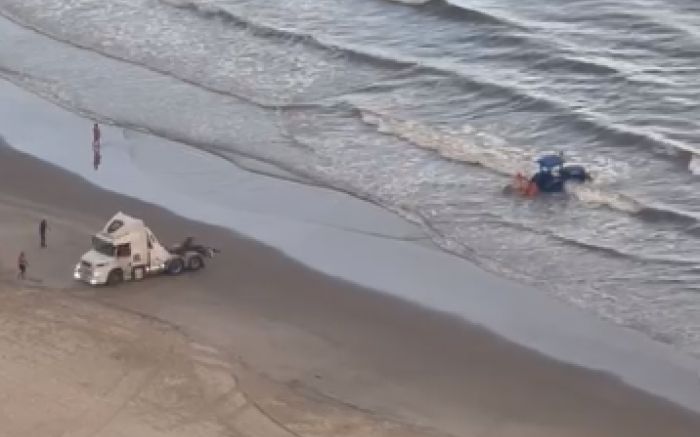 Trator ficou entre as ondas da praia Central (Foto: Reprodução)