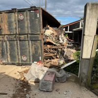 Caminhão carregado de entulho destrói muro de casa