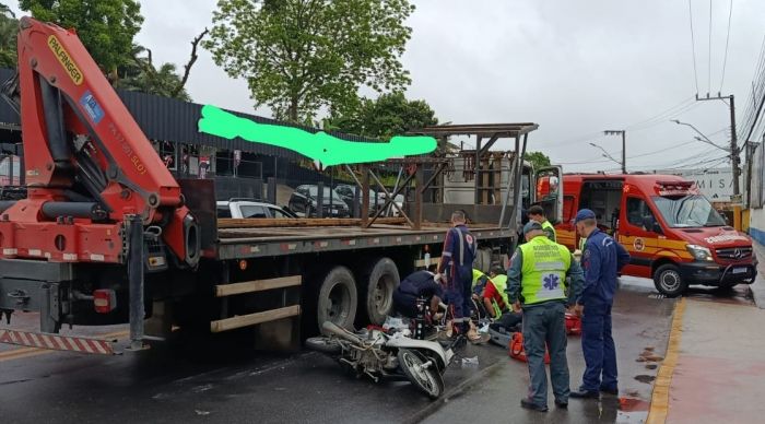 Motociclista escorregou ao tentar passar entre dois caminhões e caiu debaixo do rodado (Foto: Reprodução)