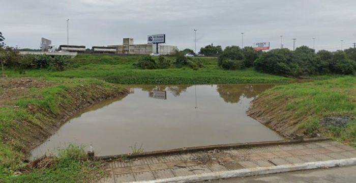 O esgoto a céu aberto pode ser encontrado a 30 metros da BR 101, em Canhanduba (Foto: Reprodução)