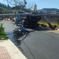 Poste cai em cima de caminhão da prefeitura e quase acerta motociclista