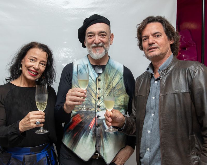 Arte - A artista plástica Christy e o fotógrafo J.C. Bergamo durante a abertura da Cromática Experience, vernissage que lançou também a Cazah Art Gallery, em Itapema. O evento apresentou a dupla de novos curadores da galeria e contou ainda com um desfile de moda. Na foto, Christy e J.C. Bergamo aparecem ao lado do escultor moçambicano, Emanuel Nunes. (foto: Amanda Loch)